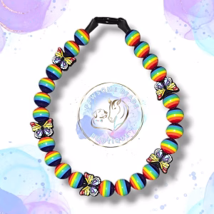 Custom made beaded dog collar made from 20mm acrylic beads in pride colours and features an butterfly shaped silicone bead